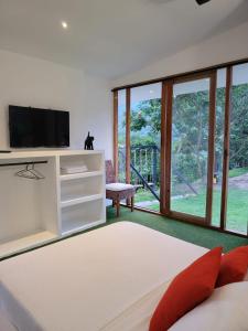 a living room with a tv and a large window at Casa Ensueño Hogar Boutique in Guaduas