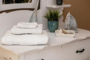 uma pilha de toalhas num balcão na casa de banho em Pepperell Place Inn Inc. em St. Peter's