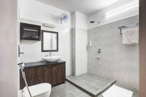 a bathroom with a sink and a toilet and a mirror at Tejdeep - A boutique 3BHK homestay in Jaipur