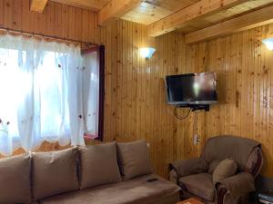 a living room with a couch and a flat screen tv at Žabljak Getaway Rental in Žabljak