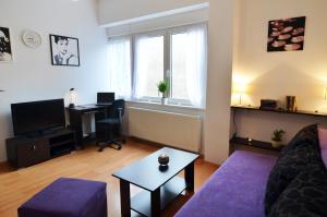 sala de estar con sofá, escritorio y ventana en Barbara and Khaleesi Apartments, en Zagreb