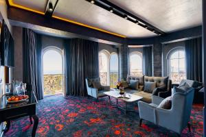 a living room with a couch and chairs and windows at Tapis Rouge Design Boutique Hotel in Batumi