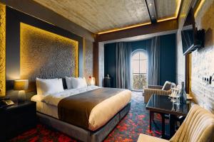a hotel room with a large bed and a chair at Tapis Rouge Design Boutique Hotel in Batumi +126 photos