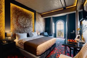 巴統的住宿－Tapis Rouge Design Boutique Hotel，酒店客房设有一张大床和一张书桌。