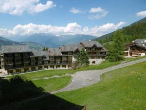 a large building with a road next to a mountain at Appartement Velaer Valmorel in Valmorel