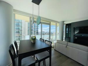 a dining room with a table and chairs and a kitchen at Deluxe 2 bedroom suite downtown free parking with pool and Air Conditioning in Victoria