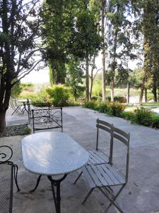 un tavolo e sedie seduti in un parco di Montresora, villa con piscina privata tra il Lago di Garda e Verona a Sona