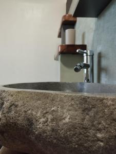 lavabo de piedra con grifo en el baño en Quiero Más B&B en San Nicola Arcella