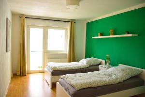 two beds in a room with a green wall at Haus mit 3 Apartments im Zentrum von Rostock in Rostock