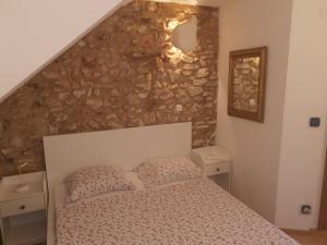 a bedroom with a bed and a stone wall at George's rooms in Stari Grad