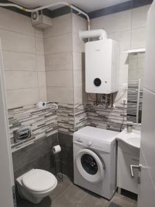 ein Badezimmer mit Waschmaschine und Toilette in der Unterkunft Apartman Batuda,moderno opremljen apartman u centru Đurđevca, u cijeni WELLNESS, sauna, bazen u obližnjem hotelu, mini zoo, 5G internet, R1 račun, SELF CHECKIN, WELLNESS NO AVAILABLE 1 8-15 8 in Ðurđevac + 32 Fotos