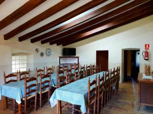 a dining room with a long table and chairs at Masía para grupos con piscina privada-28 pax in Girona