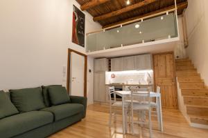 een woonkamer met een groene bank en een tafel bij Casa Materdei in Napels