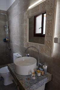 a bathroom with a sink and a toilet and a mirror at Casa Di Sofia in Rethymno Town