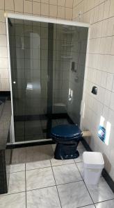 y baño con aseo azul y ducha. en Suíte Residencial320 - Timbó, en Timbó