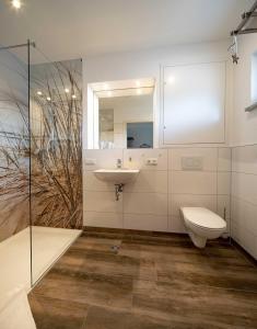 La salle de bains est pourvue de toilettes et d'un lavabo. dans l'établissement Boardinghouse Kastanienring, à Reichertshausen