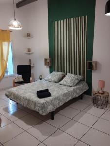 - une chambre avec un lit et un mur vert dans l'établissement studio Aude, à Lézignan-Corbières