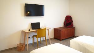 Cette chambre comprend un bureau avec un ordinateur portable et un sac à dos rouge. dans l'établissement Anima Franca Bed and breakfast, à Greve in Chianti