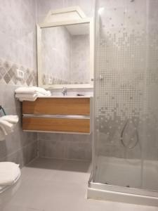 y baño con ducha y lavamanos. en Hotel Neptunia Skanes en Monastir