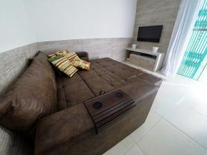 un gran sofá marrón sentado en una sala de estar en A195 - Ed. Giardino D'Itália, apto térreo, en Bombinhas