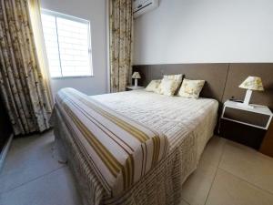 1 dormitorio con 1 cama grande y ventana en A195 - Ed. Giardino D'Itália, apto térreo, en Bombinhas