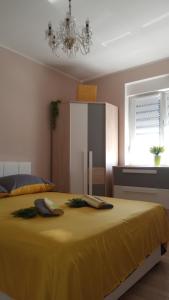 a bedroom with a large yellow bed with a chandelier at Luxor4 in Kaštela