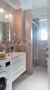 a bathroom with a washing machine and a shower at Luxor4 in Kaštela