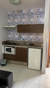 cocina con fregadero y microondas en Apartamentos Boulevard, en Caldas Novas