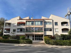 a large apartment building with a parking lot at Studio climatisé avec jardin et plage à 250m in Saint-Mandrier-sur-Mer