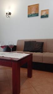 Dois copos de vinho numa mesa em frente a um sofá. em South Side em Athanion