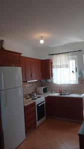 a kitchen with wooden cabinets and a white refrigerator at South Side in Athani
