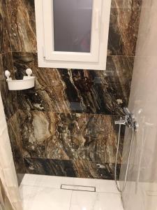 een badkamer met een wastafel en een douche met een spiegel bij LUXURY IPOGA in Athene
