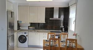 a kitchen with a table and chairs and a kitchen with a washing machine at Apartamento luminoso 3 pièces, 4 personnes en Hendaya - aparcamiento gratuito in Hendaye