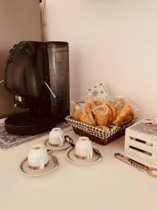 una mesa con dos tazas y una cesta de pan en La casa di Nonna Rosa, en Sant'Agnello