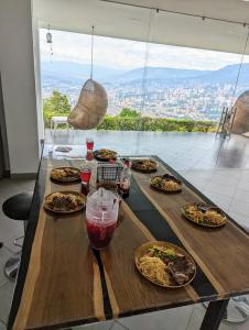 a table with plates of food on it with a view at Nomad Finca in Envigado