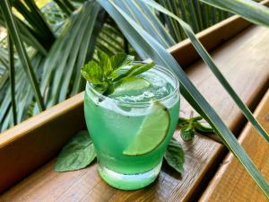 a drink with a lime and mint on a wooden table at Greengos Hotel in Lanquín