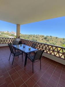 a table and chairs on a balcony with a view at El Rinconcito in Torre de Benagalbón