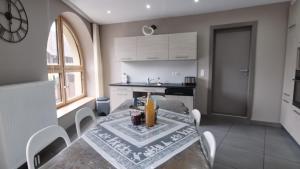 a kitchen with a table and chairs in a room at S'Harzala Taupe in Bergheim