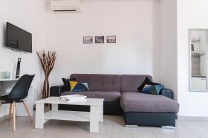 a living room with a purple couch and a table at Apartments Time For Sea in Koper