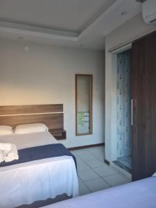 a bedroom with a bed and a sliding glass door at Pousada Caravela in Arraial do Cabo