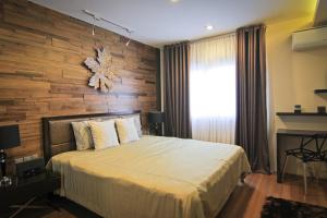 a bedroom with a large bed with a wooden wall at Boracay Suites in Boracay