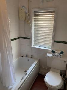 a bathroom with a tub and a toilet and a sink at The Angel Inn Stourport in Stourport