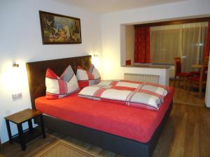a bedroom with a bed with red and white pillows at Gästehaus Birkenheim in Zell am Ziller
