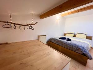 een slaapkamer met een bed en een houten vloer bij Appartement avec terrasse arborée proche LOURMARIN in Cadenet