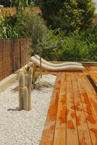 una terraza de madera con un banco en un jardín en Sacré Coeur d'Ambrussum en Lunel