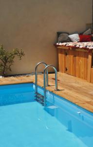 una piscina en una habitación con terraza de madera en Sacré Coeur d'Ambrussum en Lunel