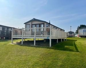a large house with a deck on a lawn at The best views on site. Haven Reighton Sands Filey in Reighton