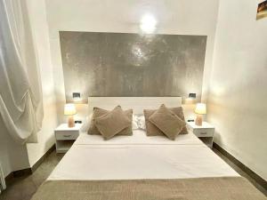 a bedroom with a large white bed with two lamps at Homelink Firenze - The Key in Florence