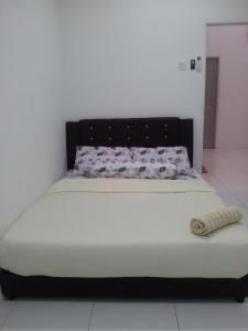 a bed with a black headboard in a room at Aalisha Pulau Langkawi House in Kuah