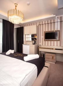 Cette chambre comprend un grand lit et une télévision. dans l'établissement Pelit Park Hotel, à Trabzon